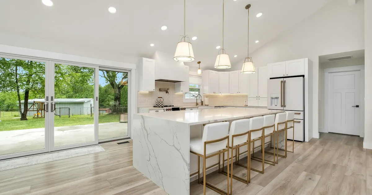 Open kitchen with a long island and a light gray plank floor