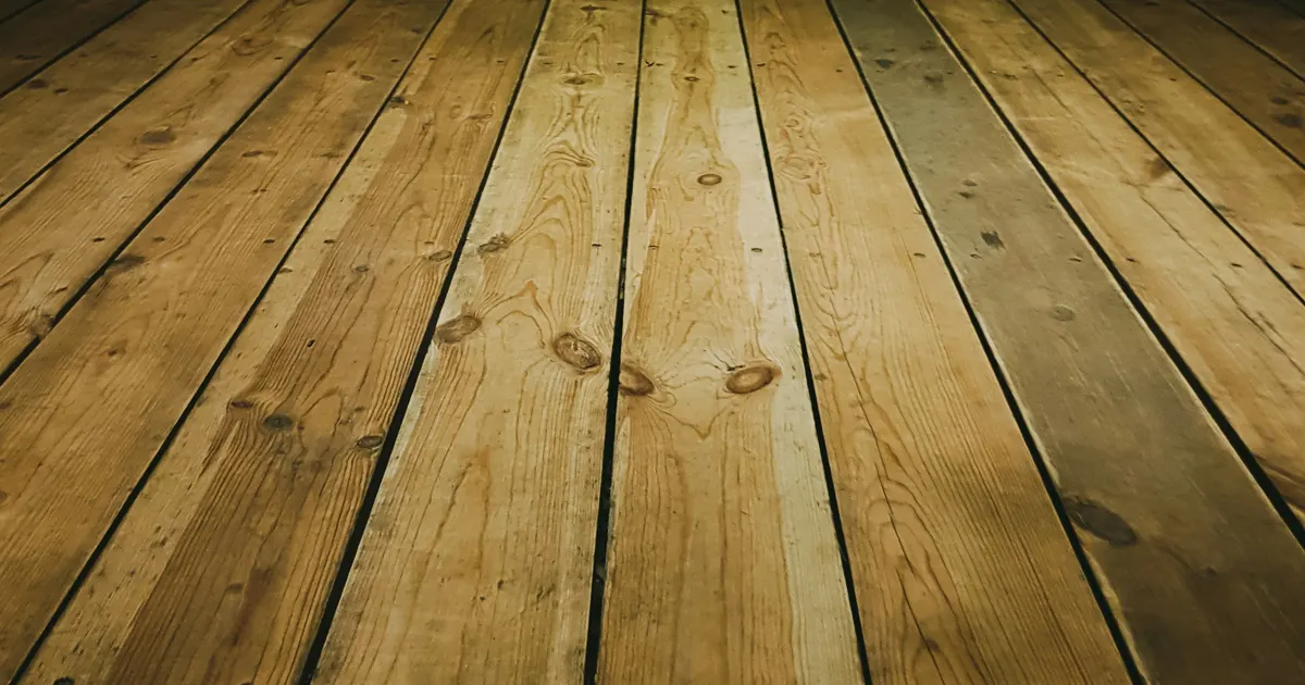 Solid wood floorboards running into the distance in low warm light